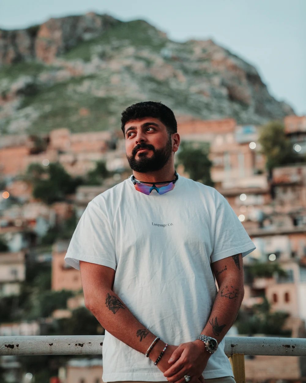 Allan Kamuran standing on a balcony with a mountain landscape behind him